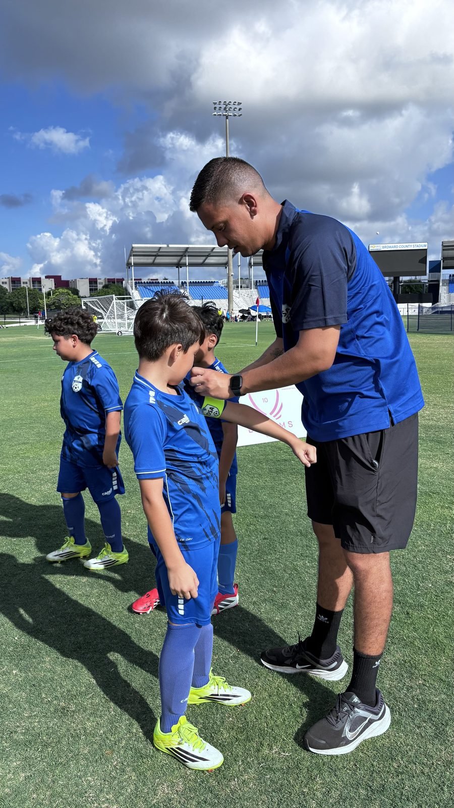 DSA coach helping a young player on the field