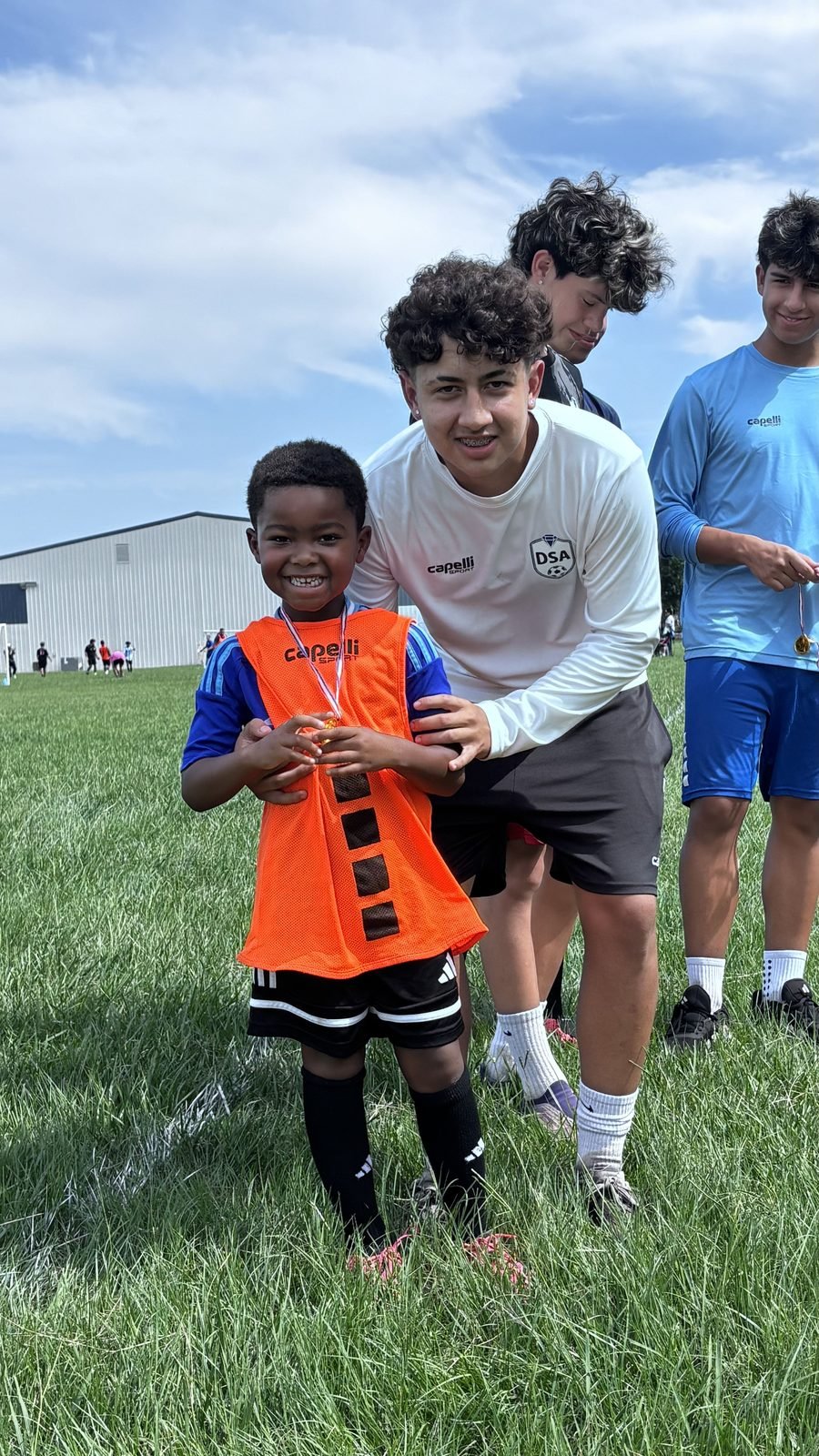 DSA mentor supporting a young player on the field